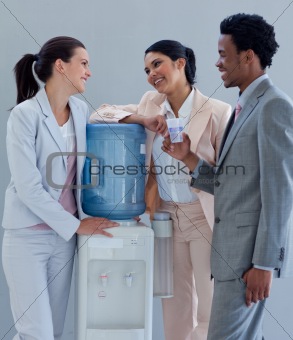 Business people speaking next to a water cooler