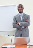 Confident ethnic businessman in office with folded arms