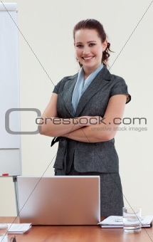 Beautiful businesswoman with folded arms in office