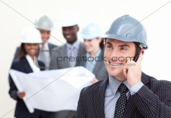 Confident male architect with his team in the background