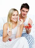 Couple celebrating an engagement with strawberries and champagne