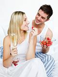 Lovers celebrating an engagement with strawberries and champagne