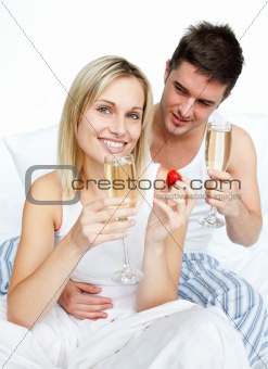 Couple eating strawberries and drinking champagne