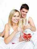 Couple toasting with champagne and strawberries to an engagement