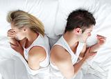 Sad and angry couple lying in bed separately. Marriage trouble