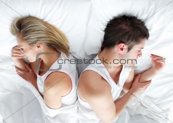 Sad and angry couple lying in bed separately. Marriage trouble