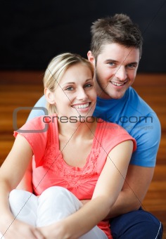Lovers sitting together on the floor and smiling