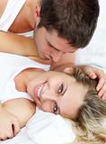 Man kissing his grilfriend in bed