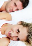 Beautiful smiling woman lying in bed with her boyfriend