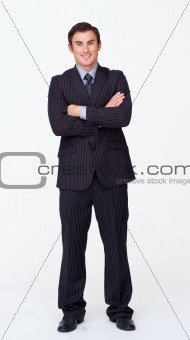 Smiling businessman with folded arms against white