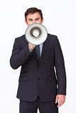 Handsome businessman shouting through a megaphone