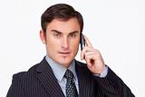 Portrait of a serious businessman on phone against white