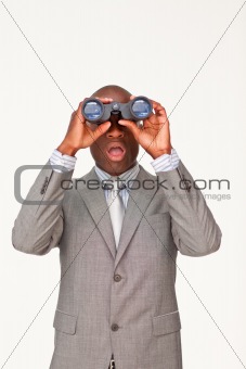 Surprised Afro-American businessman looking through binoculars