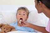 Nurse checking little boy throat in hospital