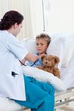 Female doctor listening to a child chest with stethoscope