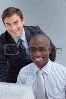 Smiling businessmen using a computer together