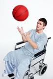 Patient in wheelchair playing with a basket ball