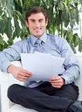Businessman reading papers and smiling at the camera