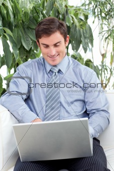 Businessman using a laptop on couch