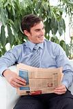 Relaxed businessman reading a newspaper