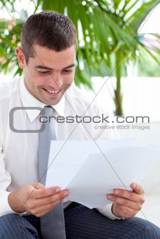 Businessman studying some documents on sofa
