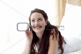 Beautiful woman in bed talking on phone