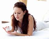 Worried woman in bed taking pills