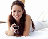 Beautiful woman in bed holding a remote