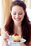 Smiling woman eating a sweet dessert