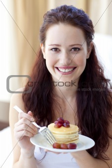 Smiling woman eating a sweet dessert