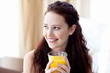 Woman drinking orange juice in bedroom