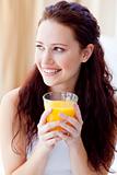 Portrait of woman drinking orange juice in bedroom