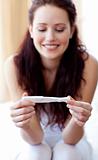 Happy woman looking at a pregnancy test
