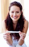 Smiling woman holding a pregnancy test