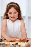 Smiling little girl baking in the kitchen