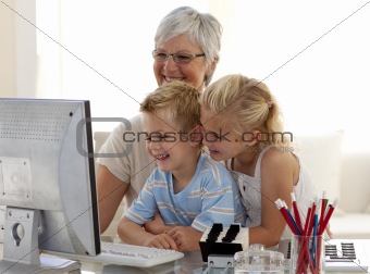 Children using a computer with their grandmother