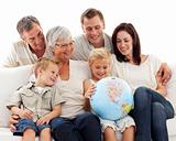 Big family on sofa looking at a terrestrial globe