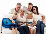 Happy family playing guitar at home