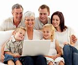 Happy family using a laptop in living-room