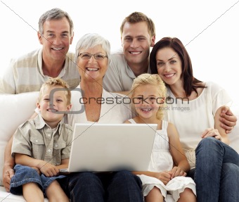 Smiling family using a laptop at home