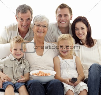 Portrait of family watching television and eating chips