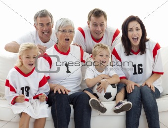 Excited family watching a football match in television