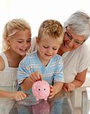Close-up of grandmother and children saving money