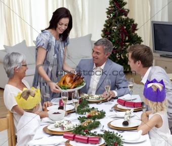 Happy family celebrating Christmas dinner with turkey