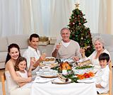 Family tusting with white wine in a Christmas dinner