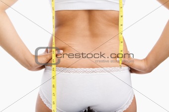 Woman back with cellulite and mesuring tape