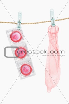 Condom hanging over white background