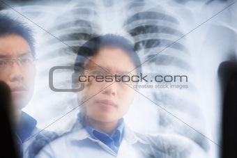 Two Asian doctor examining xray result