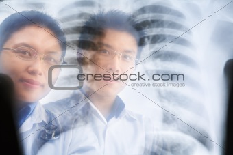 Two Asian doctor smiling through the xray result