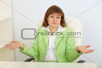 Young business woman with astonishment shrugs shoulders